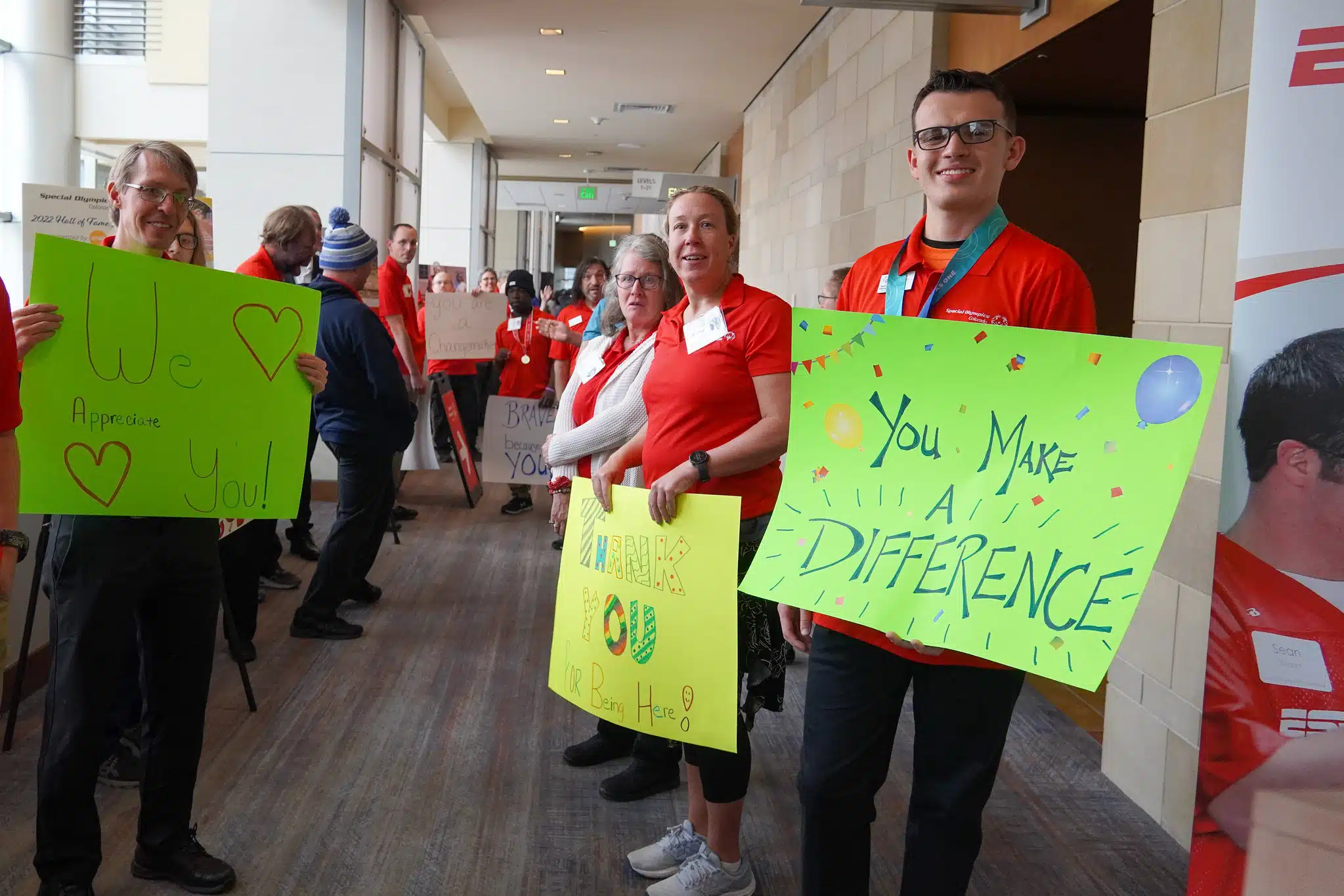 Athletes with signs welcoming guest to the Hall of Fame event