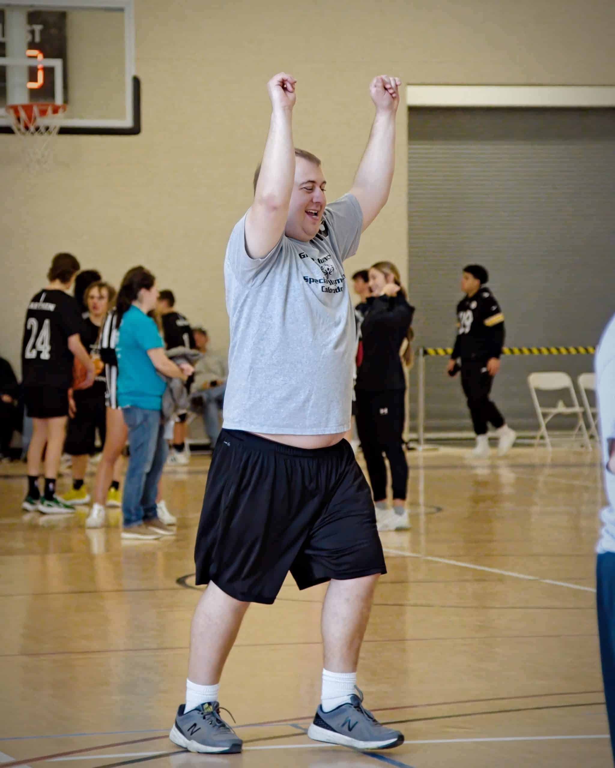 Athlete Casey Collard photo of him raising hands in the air in victory.