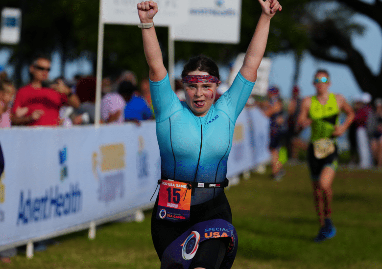 Catherine Darrow crosses the finish line at the USA Games Triathlon in 2022