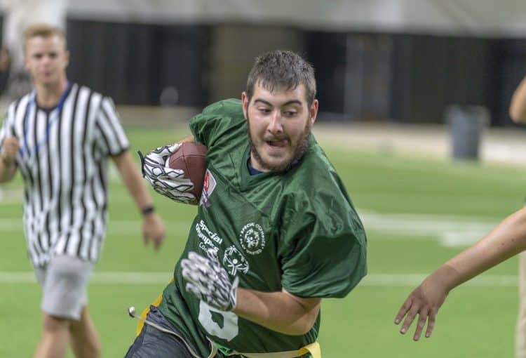 Photo of unified football player running with ball in hand