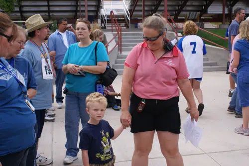 Forrest Phillips holding hands with a young athlete at a sports event